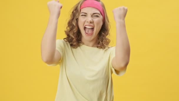 Podekscytowana Młoda Atletyczna Kobieta Odzieży Sportowej Wykonuje Gest Zwycięzcy Odizolowany — Wideo stockowe