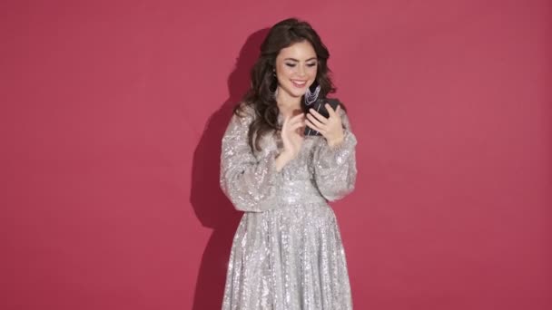 Una Joven Feliz Vestido Lentejuelas Brillantes Está Utilizando Teléfono Inteligente — Vídeo de stock