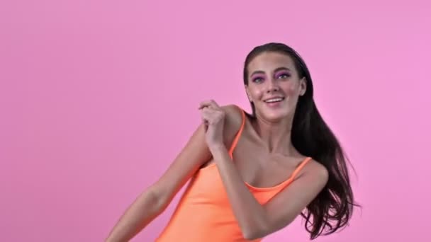 年轻迷人的积极女子被隔离在粉红墙的背景下跳舞 — 图库视频影像