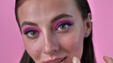 Pembe duvar arkasında izole edilmiş pozitif kadının yakın plan videosu.
