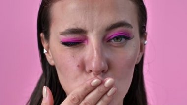 Kapalı çekim videosunda pembe duvar arkasında izole edilmiş mutlu bir kadın öpücükler savuruyor