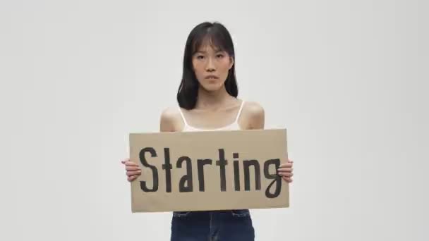 Молодая Азиатская Серьезная Женщина Позирует Изолированно Белом Фоне Держа Пустой — стоковое видео