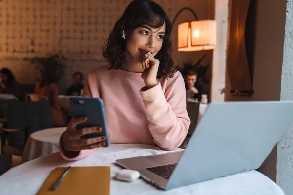 Fotografie Krásné Veselá Žena Uvnitř Kavárny Pomocí Notebooku Mobilního Telefonu — Stock fotografie