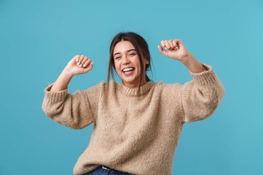 Mavi arka planda, gülen ve dans eden neşeli beyaz kadın görüntüsü