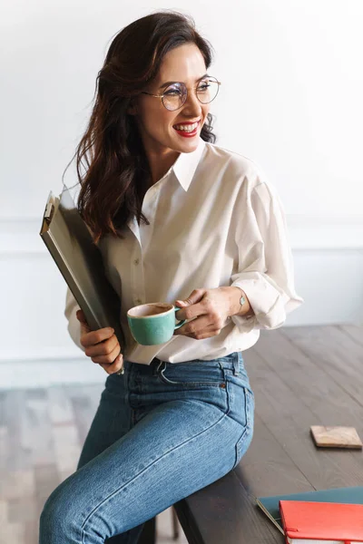 喫茶店のテーブルに座りながらノートパソコンを持っている若い女性の笑顔 コーヒーを飲む — ストック写真