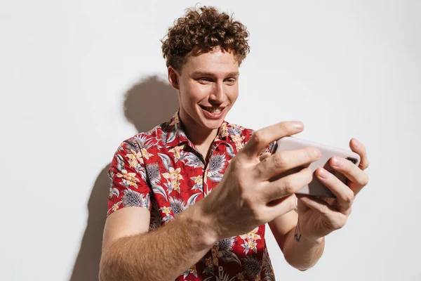 Imagen Hombre Joven Enfocado Jugando Videojuegos Teléfono Celular Sonriendo Aislado — Foto de Stock