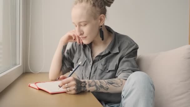 Giovane Concentrata Bella Ragazza Con Dreadlocks Indoor Scrittura Note — Video Stock