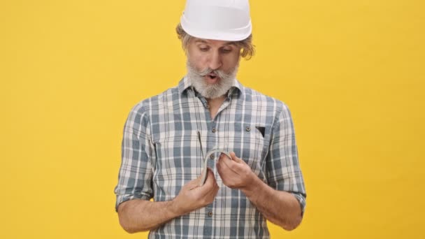 Senior Feliz Hombre Positivo Constructor Casco Aislado Sobre Fondo Amarillo — Vídeos de Stock