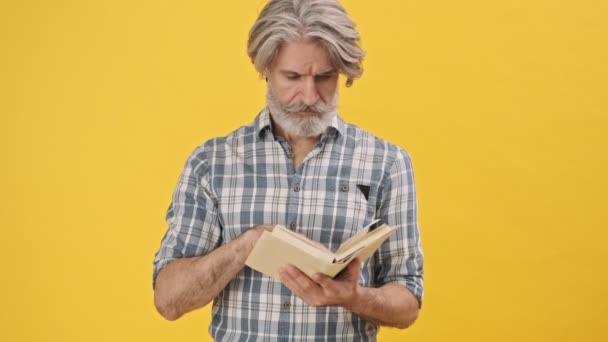 Bel Homme Concentré Isolé Sur Fond Jaune Livre Lecture Saluant — Video