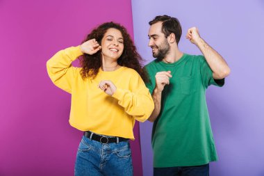 Kafkasyalı mutlu bir çift portresi. Renkli giyinmiş kadın ve erkek. Mor arka planda birlikte dans edip eğleniyorlar.