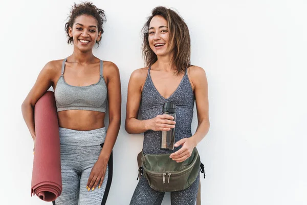 Foto Dos Jóvenes Deportistas Multiétnicas Chándal Sonriendo Sosteniendo Esterilla Yoga —  Fotos de Stock