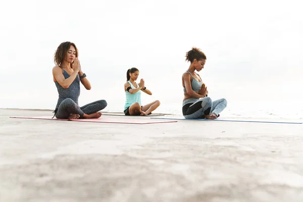 Três Mulheres Fitness Saudáveis Fazendo Exercícios Ioga Tapetes Fitness Praia — Fotografia de Stock