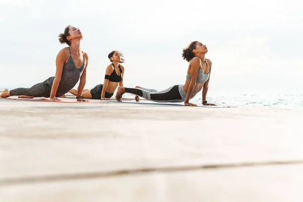 Três Mulheres Fitness Saudáveis Fazendo Exercícios Ioga Tapetes Fitness Praia — Fotografia de Stock