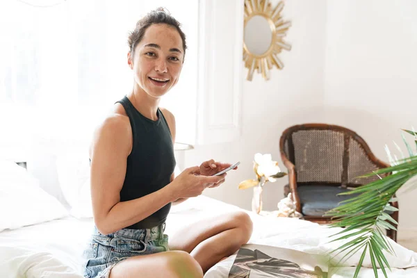 Retrato Mujer Feliz Ropa Verano Sosteniendo Teléfono Celular Mientras Lee — Foto de Stock