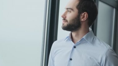 Yakışıklı pozitif memnun genç iş adamı ofiste.