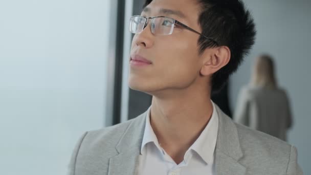 オフィスの中でハンサムなアジアの若いビジネスマン — ストック動画