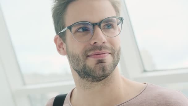 Joven Barbudo Guapo Complacido Con Gafas Está Mirando Lado Mientras — Vídeos de Stock