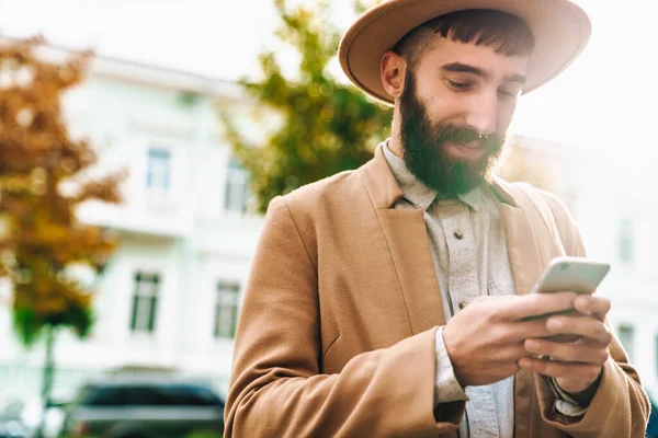 Attraktivt Leende Ung Man Bär Höstrock Och Hatt Promenader Utomhus — Stockfoto