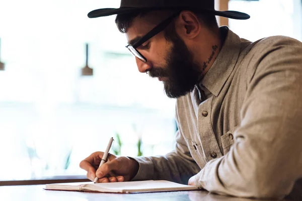 Photo Jeune Homme Sérieux Portant Des Lunettes Prenant Des Notes — Photo