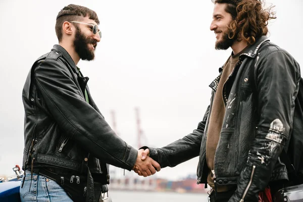 Foto Jóvenes Barbudos Motociclistas Sonriendo Apretando Las Manos Mientras Están — Foto de Stock