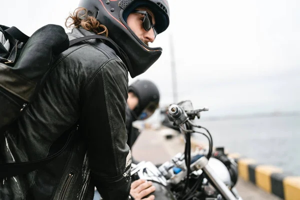 照片中 留着胡子的野蛮男子骑自行车 头戴钢盔 在海港向前看 — 图库照片