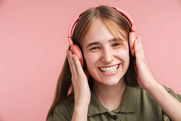 Zdjęcie Śmiesznej Białej Kobiety Używającej Słuchawek Śmiejącej Się Różowym Tle — Zdjęcie stockowe