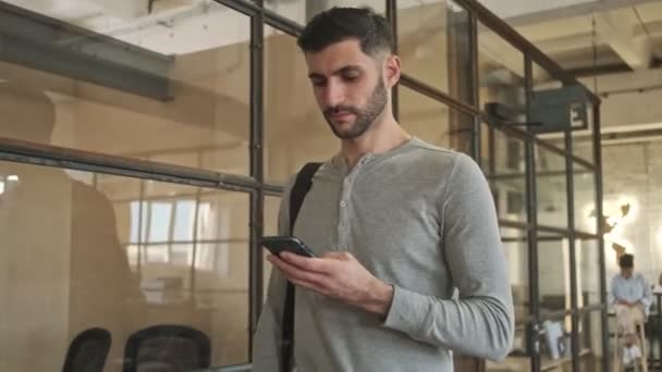Concentrado Joven Hombre Negocios Satisfecho Interior Caminando Oficina Utilizando Teléfono — Vídeos de Stock