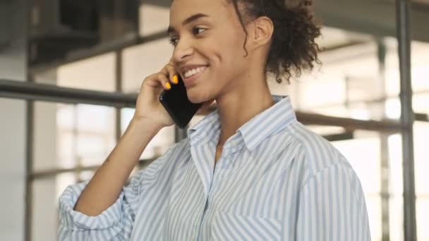Позитивная Молодая Деловая Африканка Заходит Офис Разговаривает Мобильному Телефону — стоковое видео