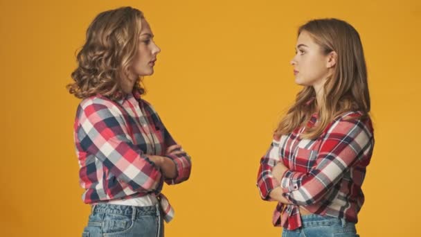 Genç Ciddi Güzel Kızlar Sarı Duvar Arkasında Konuşuyorlar — Stok video