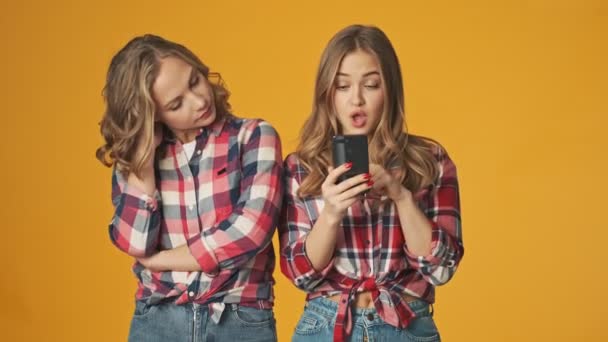 Jovens Meninas Felizes Emocionais Isolados Sobre Fundo Parede Amarela Usando — Vídeo de Stock