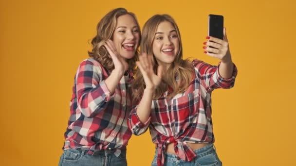 Fiatal Pozitív Csodálatos Lányok Elszigetelt Sárga Fal Háttér Beszél Mobiltelefon — Stock videók