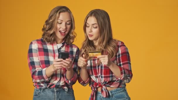 Jovens Meninas Concentradas Isoladas Sobre Fundo Parede Amarela Usando Telefone — Vídeo de Stock