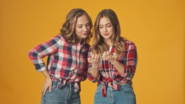 Chicas Jóvenes Amigas Hermanas Aisladas Sobre Fondo Amarillo Pared Mirando — Vídeo de stock