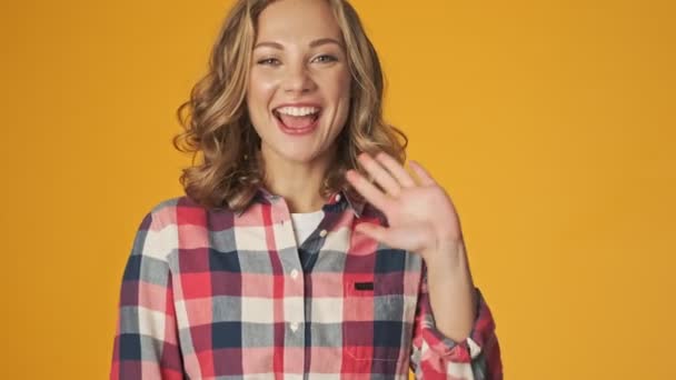 Sarı Duvarın Üzerinden Izole Edilmiş Genç Mutlu Kız Sana Sallıyor — Stok video