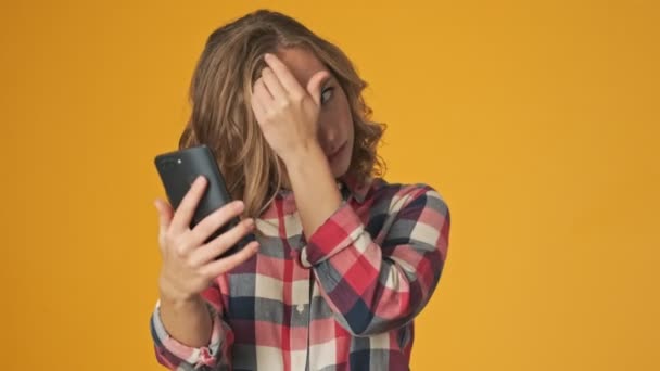 Ung Flicka Isolerad Över Gul Vägg Bakgrund Selfie Tittar Telefonen — Stockvideo