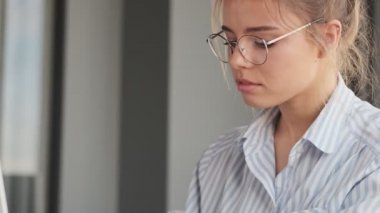 Güzel, genç ve çekici bir kız evde dizüstü bilgisayarla çalışıyor.