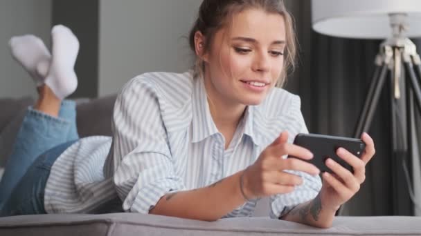 Pozitivní Mladá Žena Dívá Něco Svém Smartphonu Drží Horizontálně Zatímco — Stock video