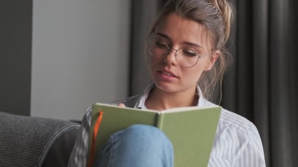 Une Belle Jeune Femme Tord Journal Assis Sur Canapé Maison — Video