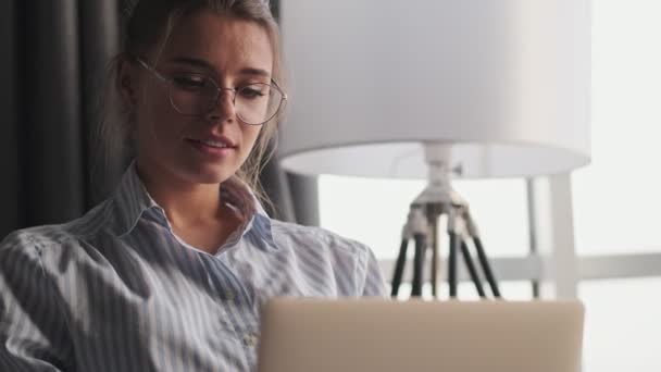 Una Joven Muy Agradable Con Gafas Está Mirando Portátil Sentado — Vídeos de Stock