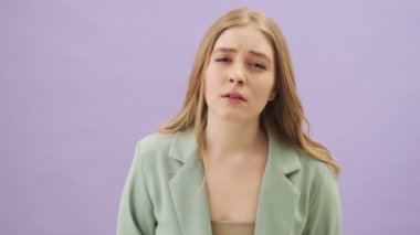 Gri arka planda yalnız duran güzel bir genç kadın kendini sıkılmış hissediyor.