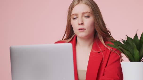 Μια Σοβαρή Νεαρή Γυναίκα Χρησιμοποιεί Τον Φορητό Υπολογιστή Της Καθισμένη — Αρχείο Βίντεο