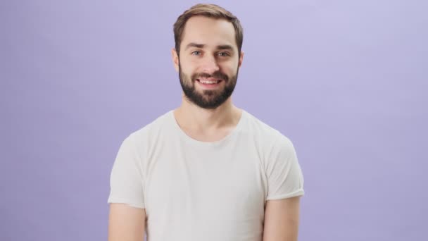 Joven Guapo Vistiendo Una Camiseta Blanca Ríe Pie Aislado Sobre — Vídeo de stock