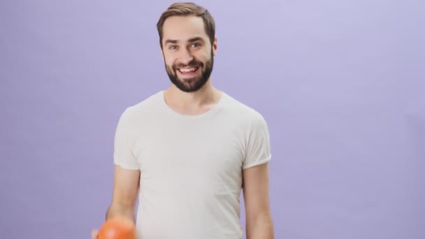 Jovem Sorrindo Positivo Vestindo Uma Camiseta Branca Está Jogando Uma — Vídeo de Stock