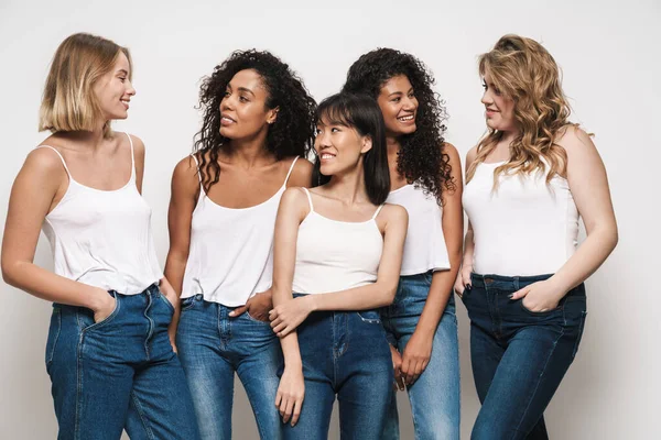 Imagem Mulheres Multinacionais Bonitas Jeans Azuis Sorrindo Conversando Juntas Isoladas — Fotografia de Stock