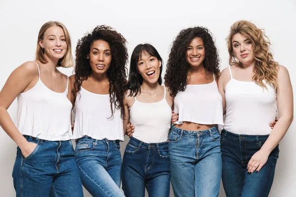 Imagen Mujeres Multinacionales Alegres Jeans Azules Sonriendo Abrazándose Juntas Aisladas — Foto de Stock