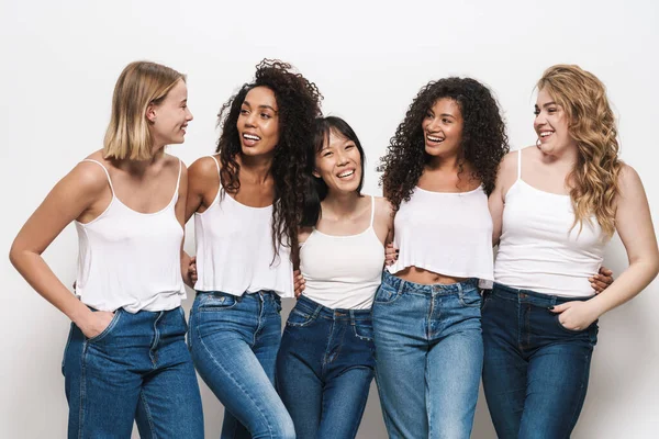 Imagen Mujeres Multinacionales Alegres Jeans Azules Sonriendo Abrazándose Juntas Aisladas — Foto de Stock