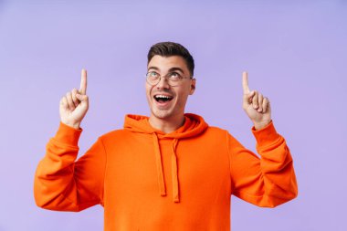 Mor arka planda izole edilmiş, gözlüklü neşeli, pozitif bir genç resmi..