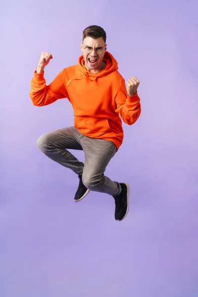 Imagen Feliz Joven Emocional Saltando Aislado Sobre Fondo Púrpura Usando — Foto de Stock