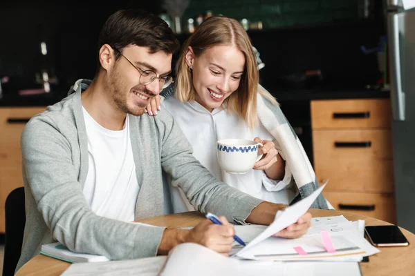 カフェで一緒に計算や書類作成をする男と女のような幸せな若いビジネスのイメージ — ストック写真