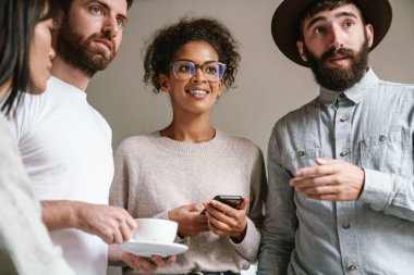 Çok ırklı genç kadın ve erkek iş adamlarının ofiste yan yana durduğu görüntüler